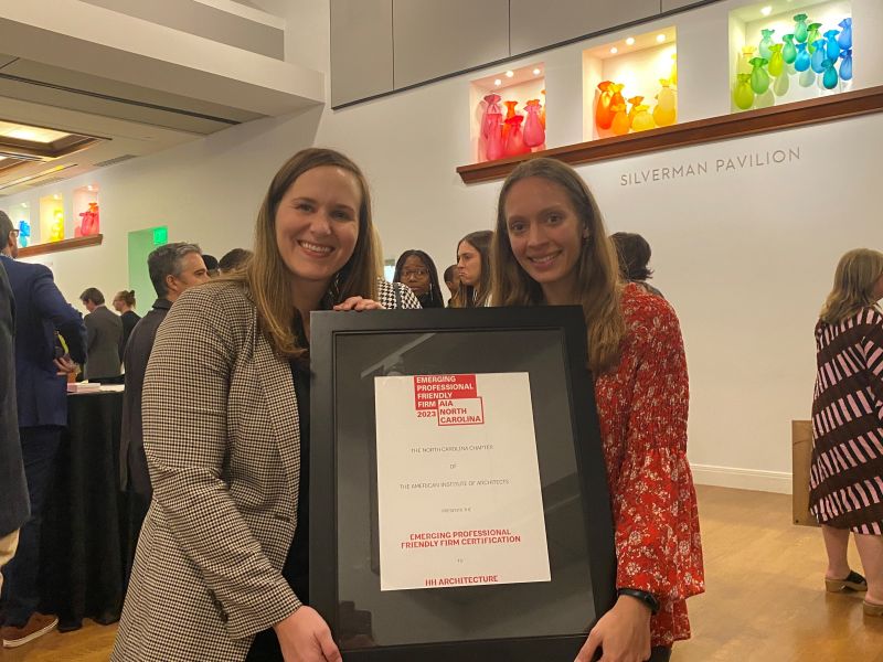Jenessa Van Deen and Maya Miller proudly displaying the Emerging Professional Friendly Firm Certification at the AIA North Carolina Awards in Charlotte, October 26, 2023