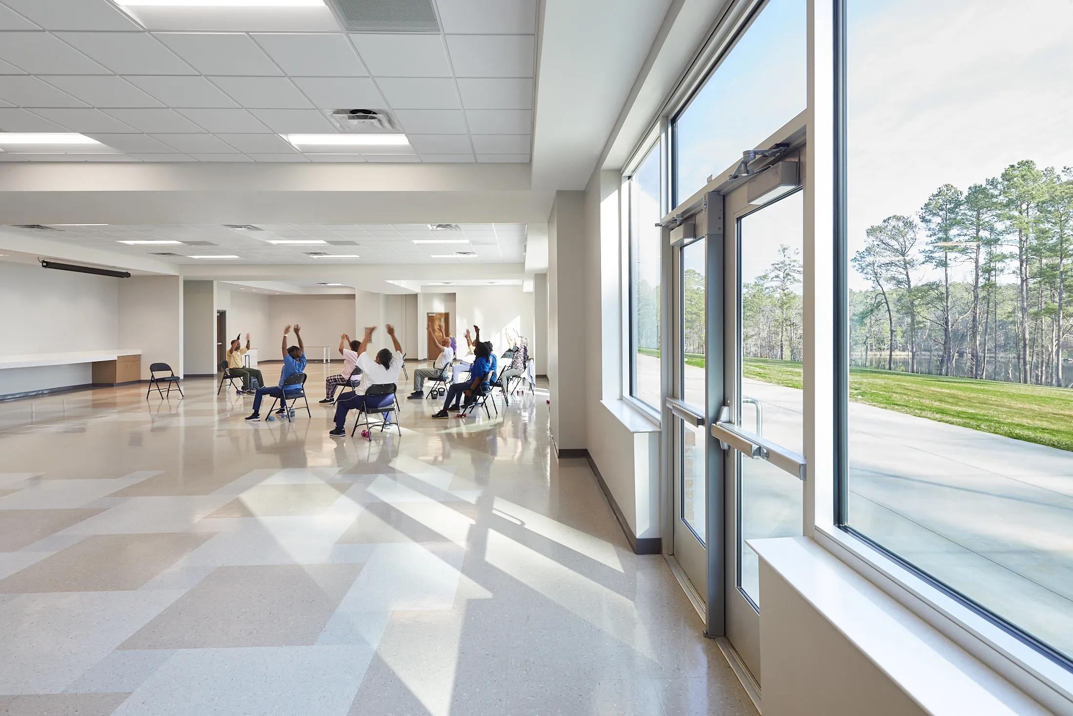 A large room with natural light at the Bill Crisp Senior Center by HH Architecture