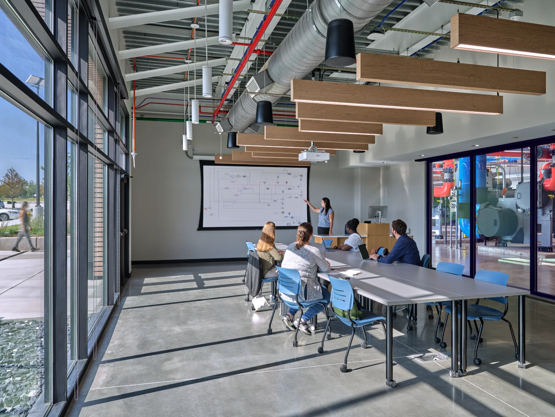 A classroom with large glass windows and natural light inside of the Central Energy Plant by HH Architecture